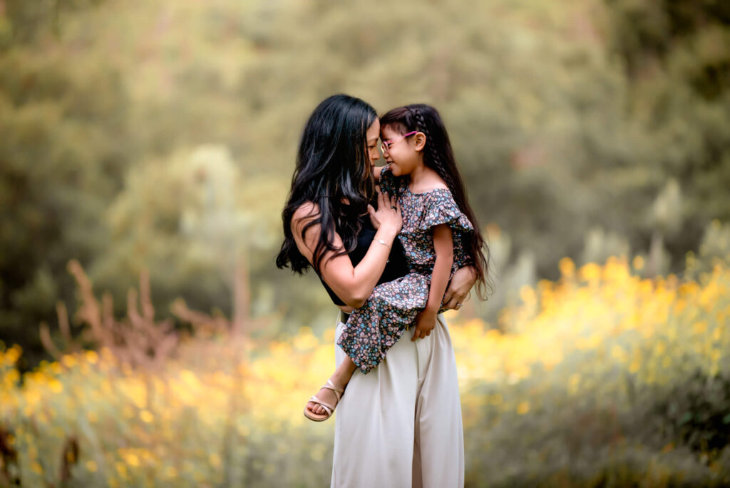 Motherhood photo of mother and daughter embraced together